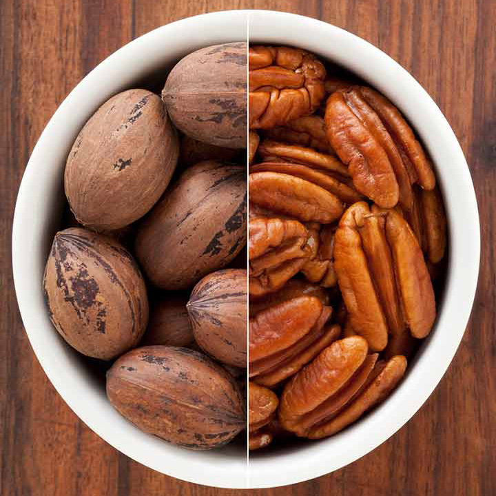 Pecans in a bowl, half shelled half unshelled